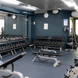 A photo of a section filled with free weights and benches