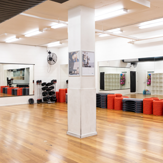 A photo of a spacious active area with balance boards, weights and a full wall mirror in the background
