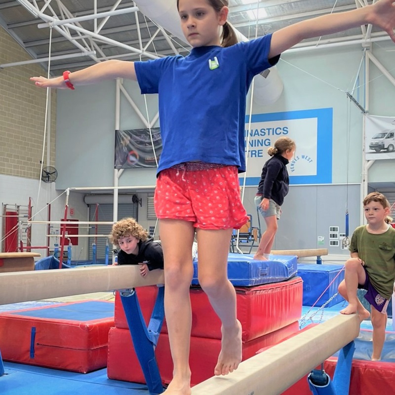 Girl walking confidently on balance beam