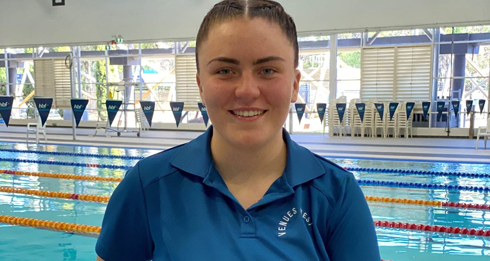 venueswest swim instructor smiling in front of lane pool